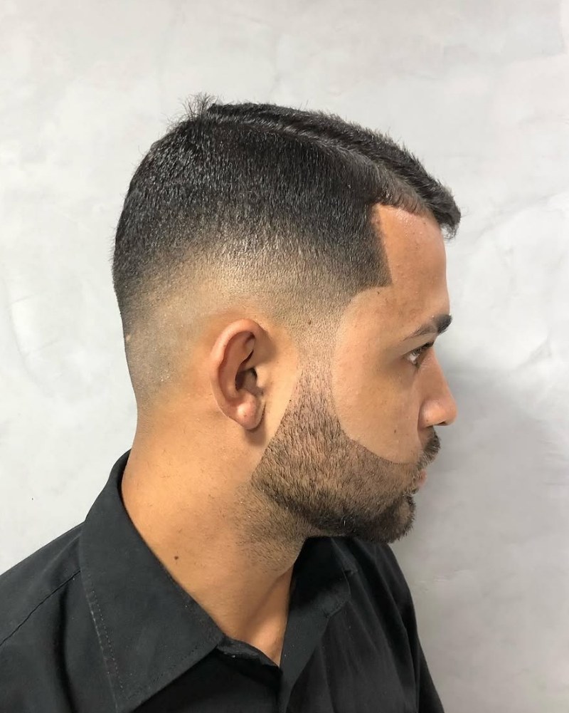 Corte degradê com barba desenhada, visto de lado