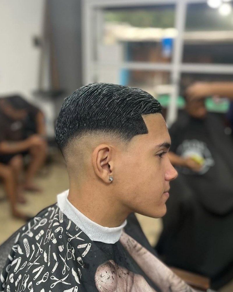 Corte degradê com o contorno da têmpora bem marcado, visto de lado